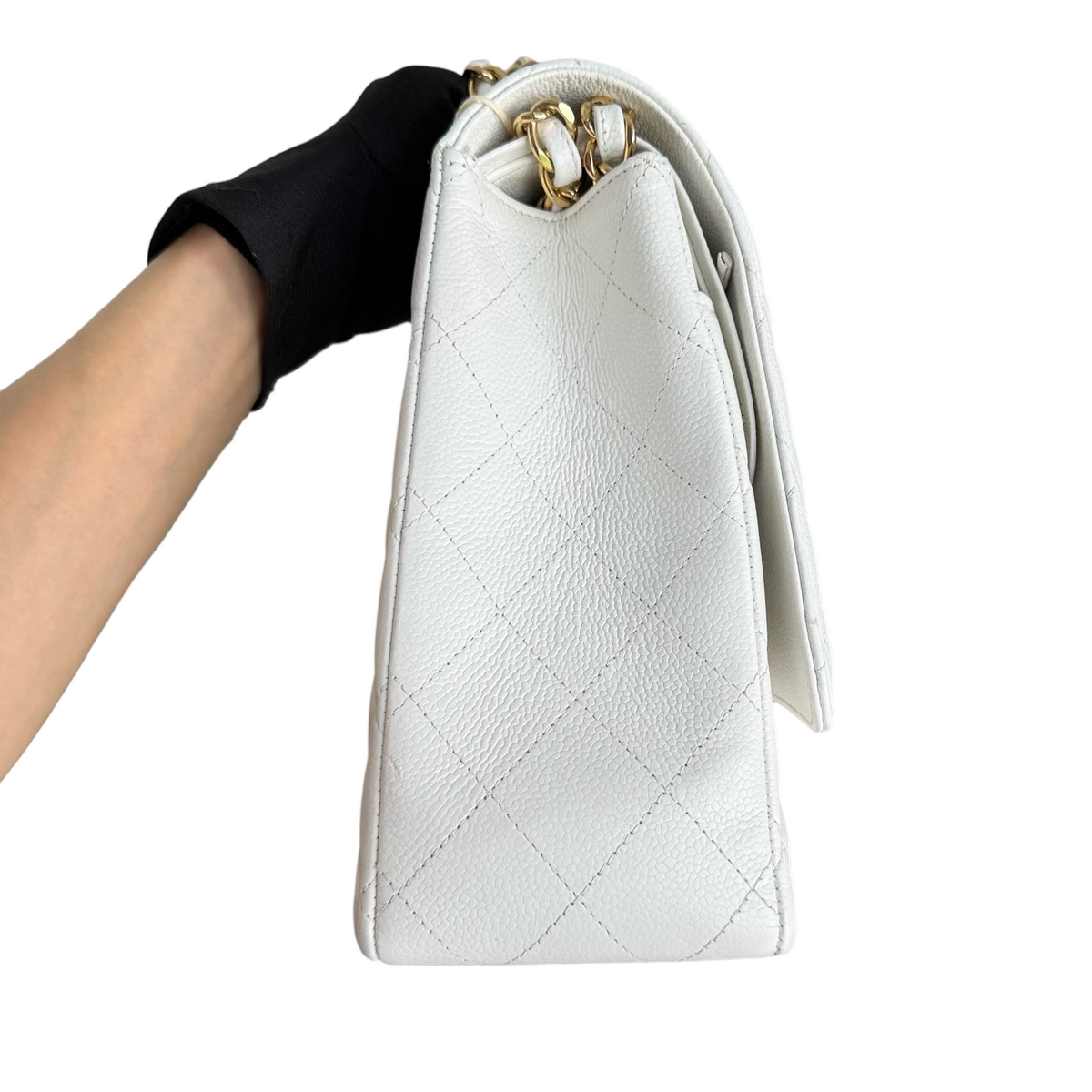 Luxury Evermore Chanel Classic Flap Maxi 手袋,白色鱼子酱纹理皮革,配有金色链条肩带和标志性菱格纹设计,侧面视角。