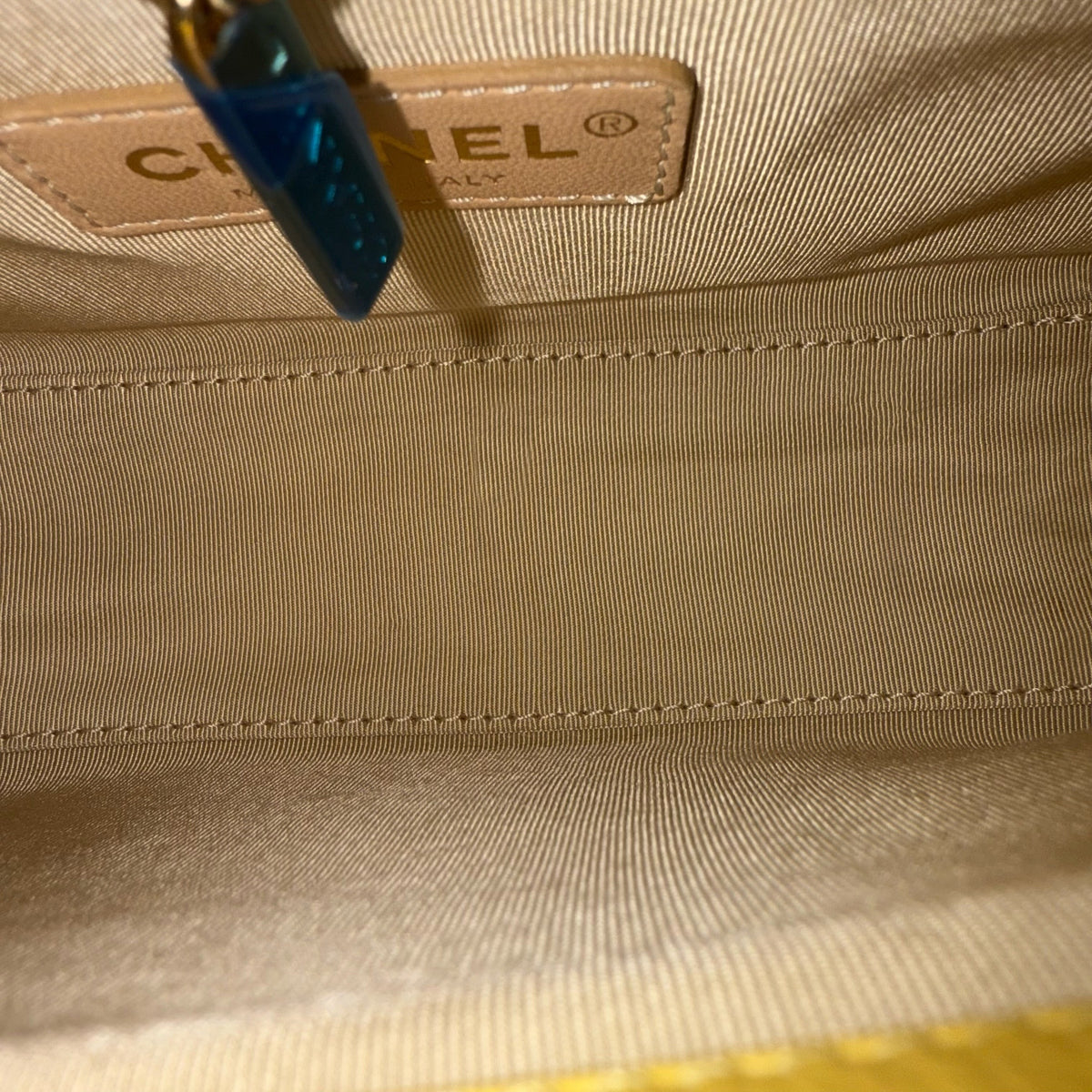 Luxury Evermore Chanel Label Click Small bag interior featuring beige fabric lining and leather logo tag