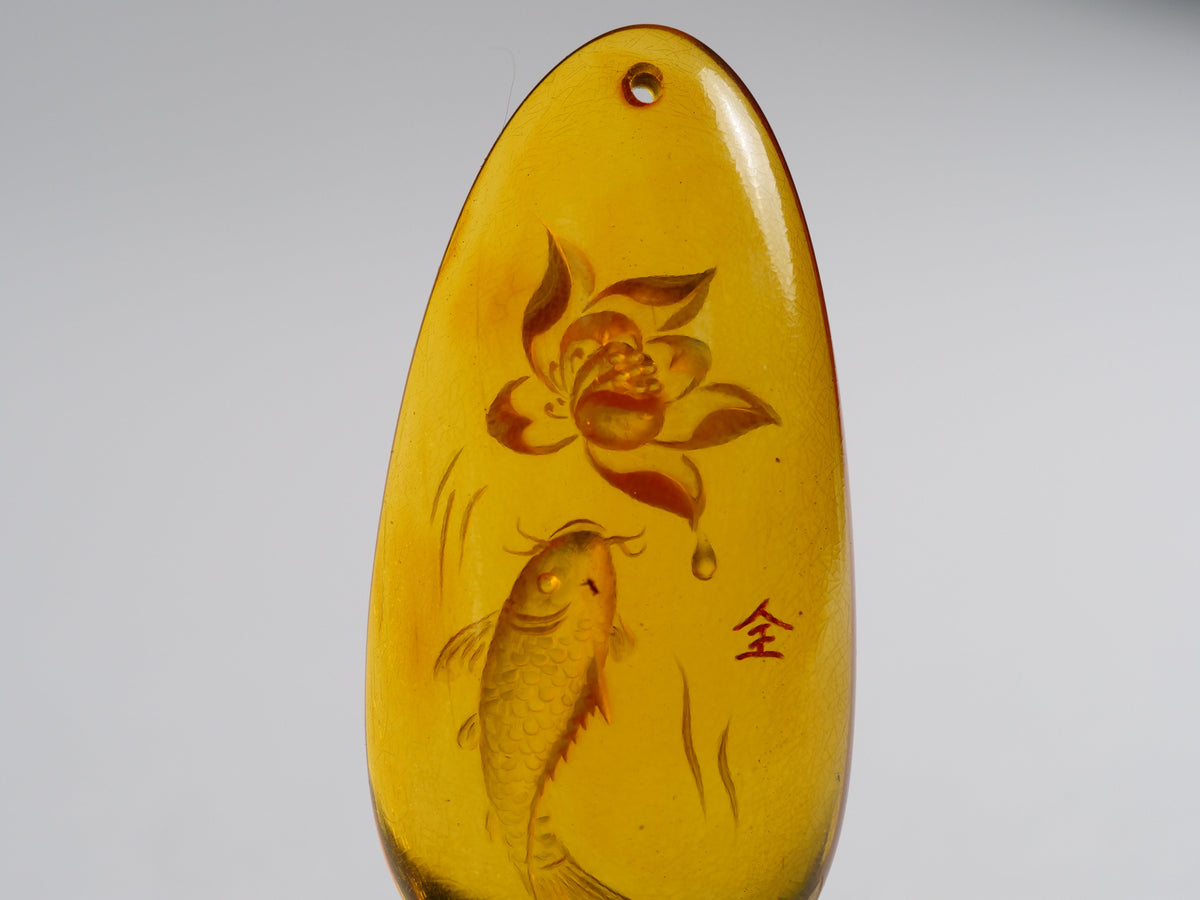 Yihen Natural Amber master carving 'Fish and Lotus'. 47 x 20mm. 28.25ct.