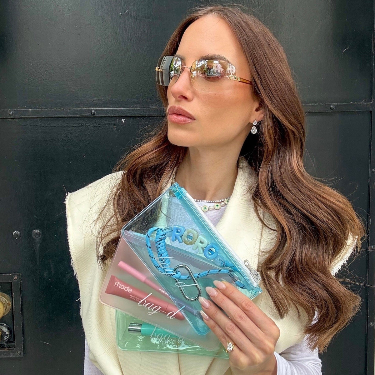 Model holds BAG-D The Everything Pouch Pastel in frosted TPU