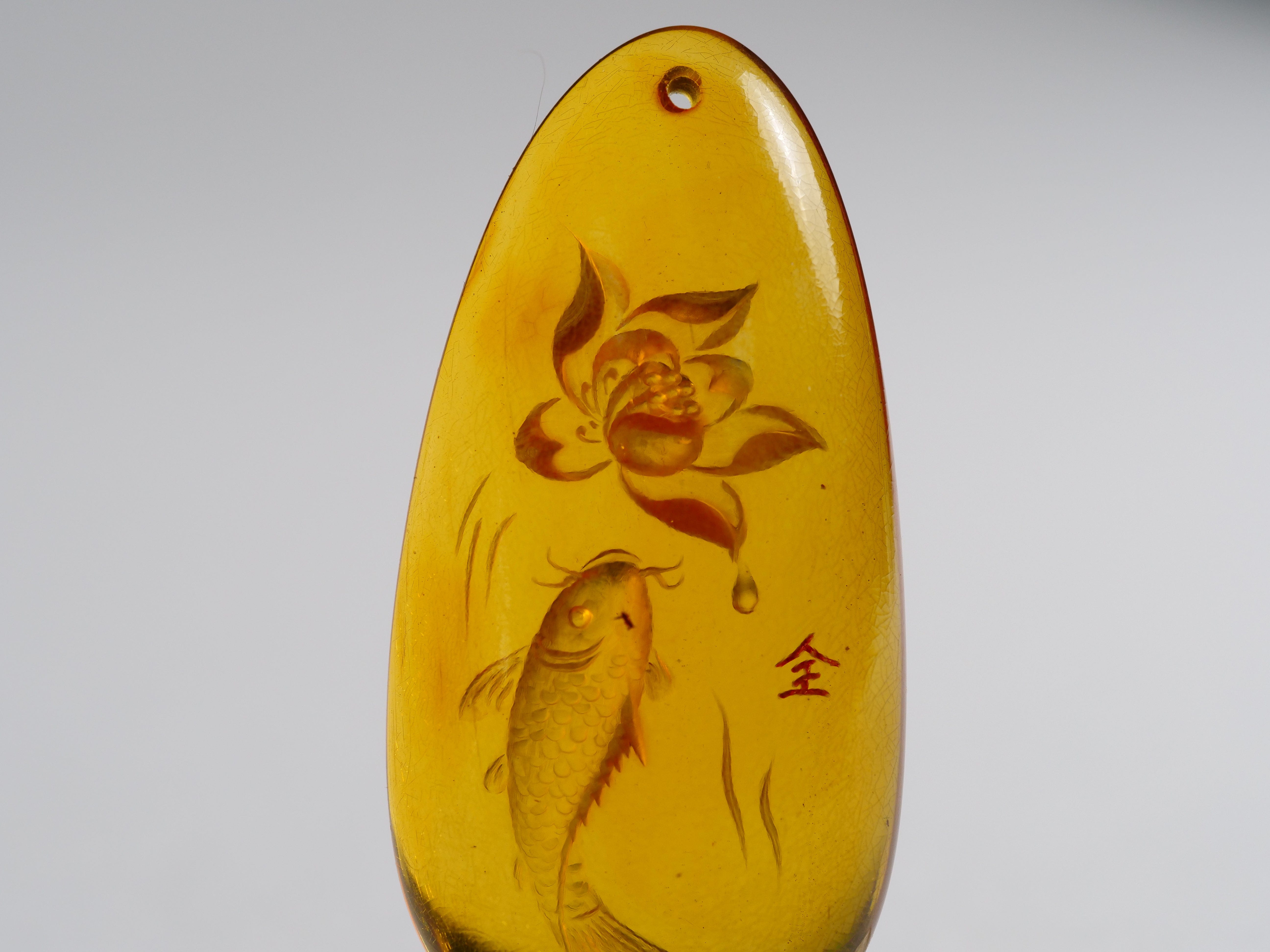 David Harry Jewels Yihen Natural Amber master carving 'Fish and Lotus'. 47 x 20mm. 28.25 cts.