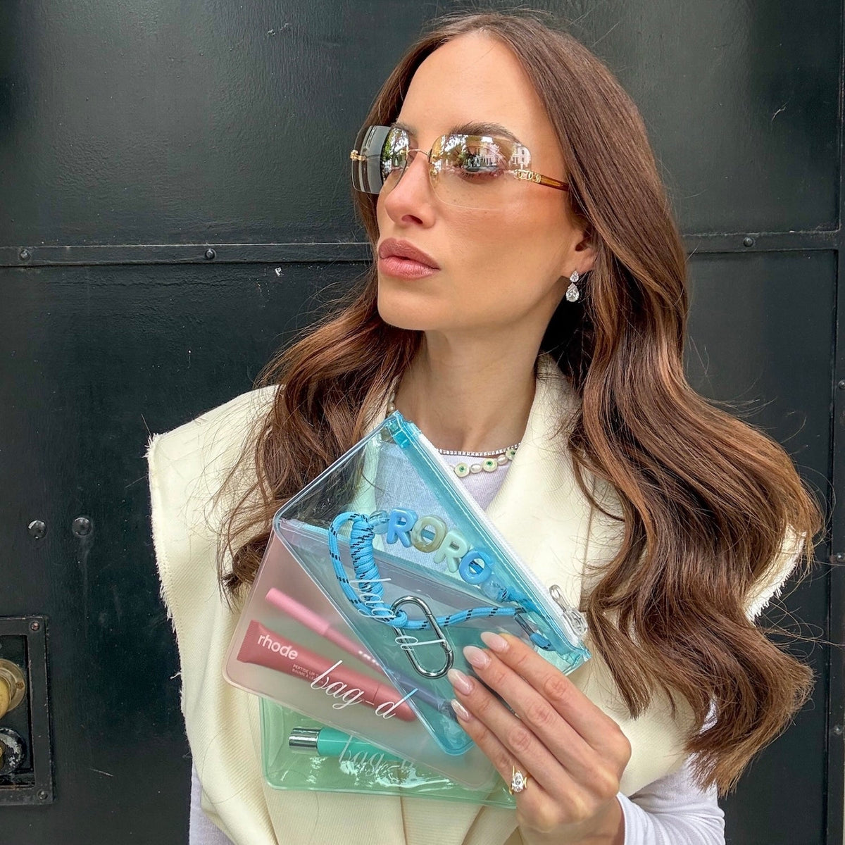 Model holds BAG-D The Everything Pouch  Pastel in frosted TPU
