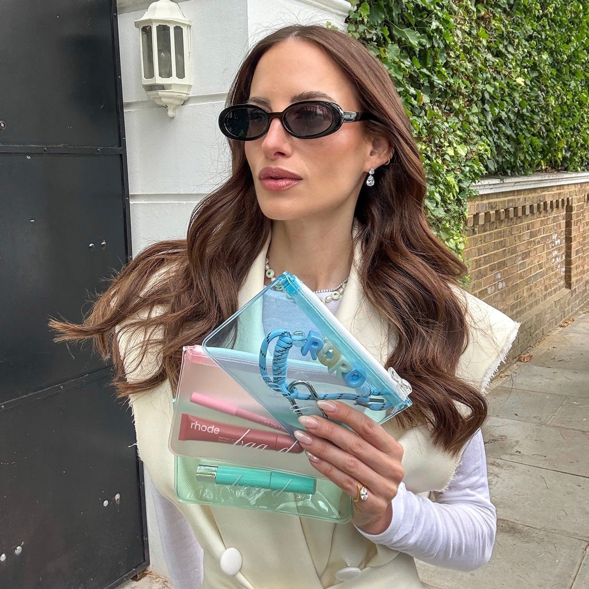 Model holds BAG-D The Everything Pouch  Pastel in frosted TPU