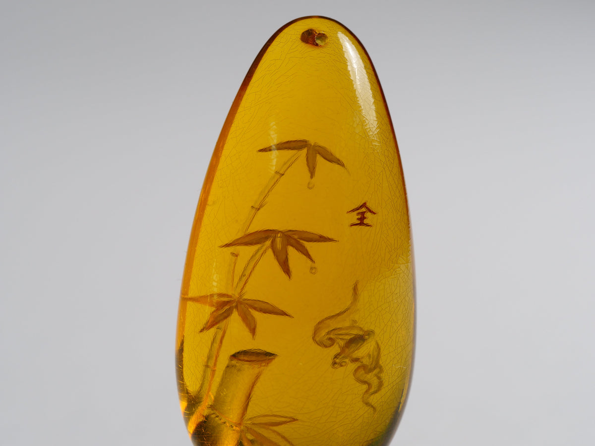 Yihen Natural Amber master carving 'Bat and Bamboo'. 44 x 20mm. 30.10ct.