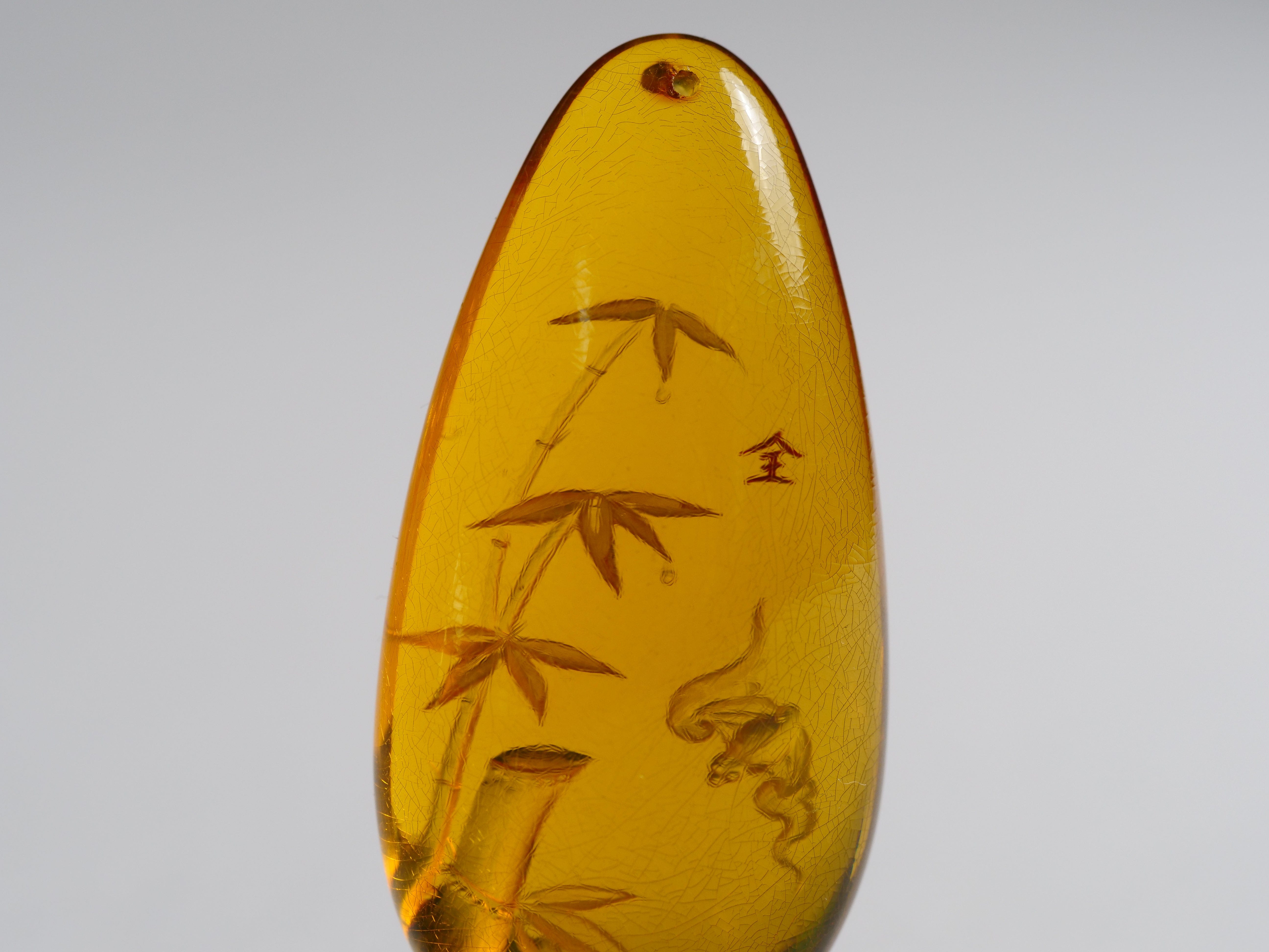 David Harry Jewels Yihen Natural Amber master carving 'Bat and Bamboo'. 44 x 20mm. 30.10 cts.