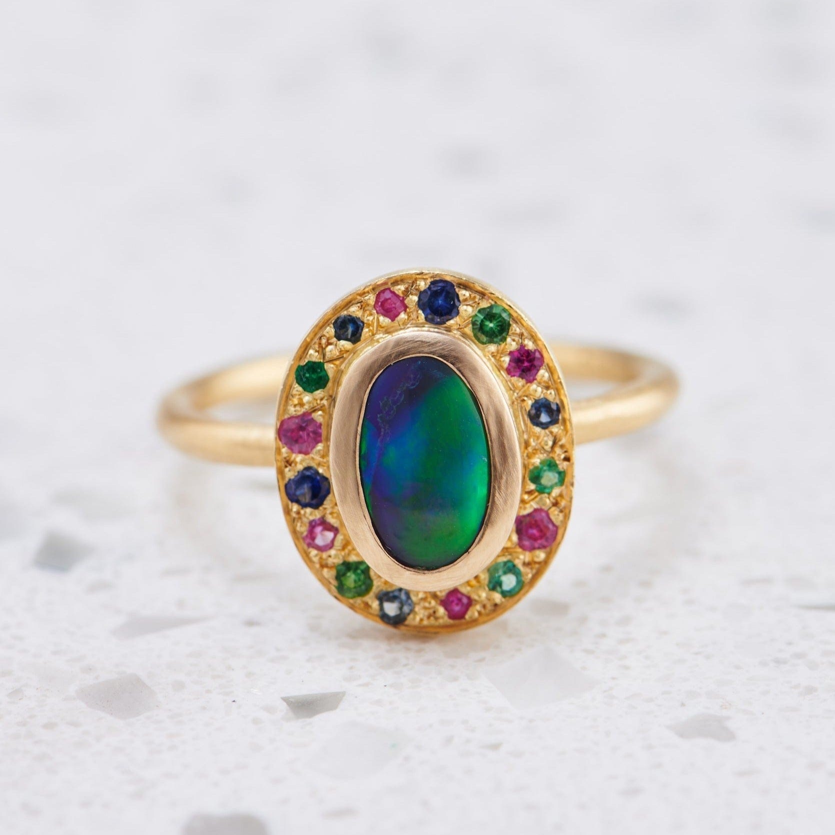 Luxury Promise Lightning Ridge Black Opal with surrounding Emeralds and Sapphires set in 18K Yellow Gold